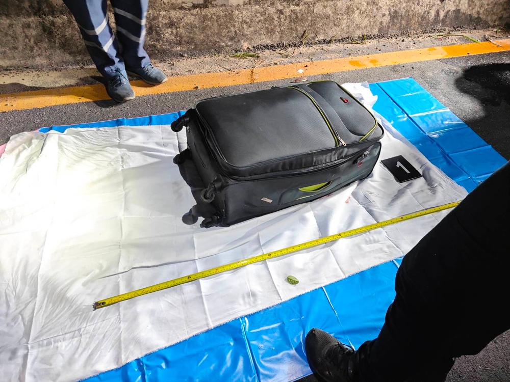 In this handout photo taken in Pattaya on June 27, 2026 and provided by Pattaya City Police Station on June 29, police officers measure a suitcase after the suspected murder of a 17-year-old Thai girl. (Photo by Handout / Pattaya City Police Station / AFP)