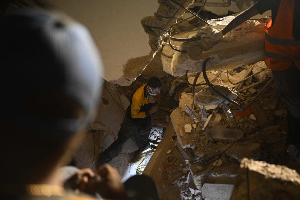 People search for their deceased relatives among the debris of a collapsed building in the Los Corales neighbourhood of Caraballeda, La Guaira State, Venezuela on July 1, 2026, following the June 24 twin earthquakes. (Photo by Federico PARRA / AFP)