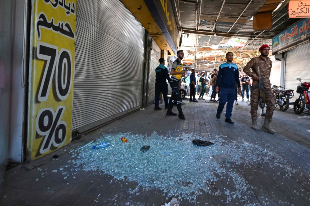 Syrian security forces gather at the site of an explosion at a cafe in the capital Damascus on July 2, 2026. A bomb went off at a cafe in central Damascus on on July 2, killing at least five people and wounding 16, Syrian authorities said. (Photo by LOUAI BESHARA / AFP)