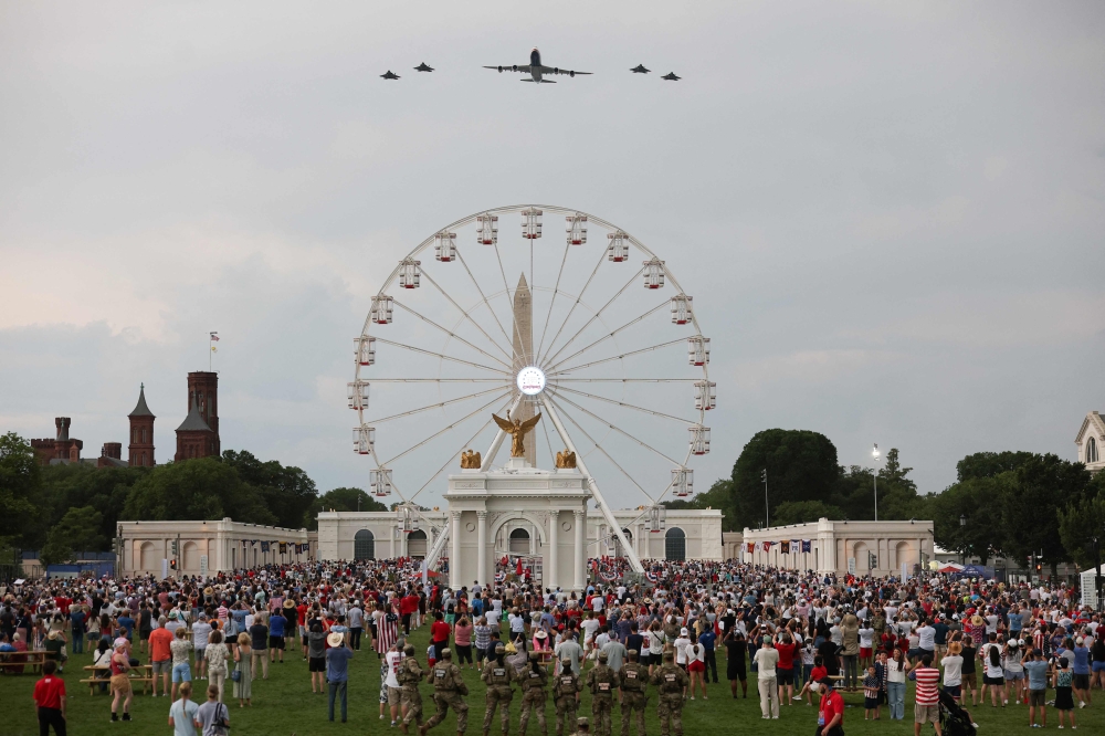 The new Air Force One escorted by US Air Force F-22 Raptors flies over the National Mall during the 