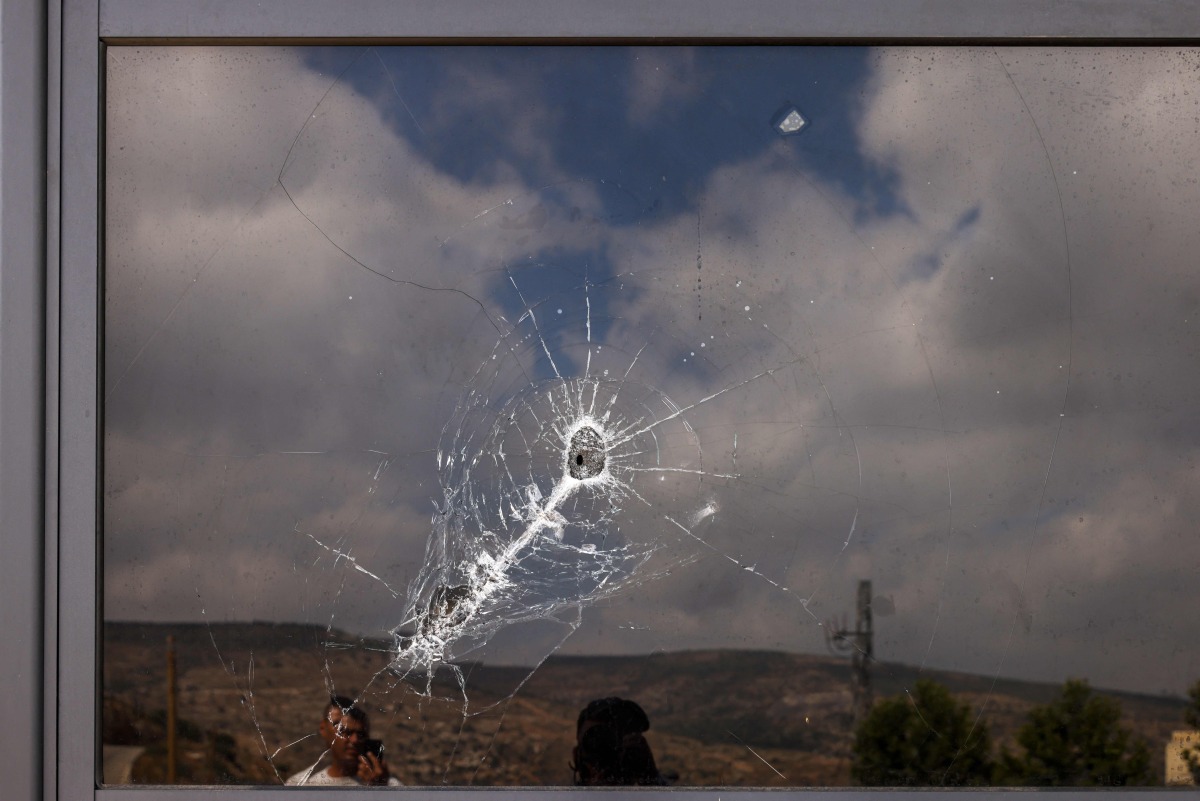 This picture shows a bullet hole on the window of a restaurant after it was burned down by settlers during an attack in the western area of the Al-Lubban ash-Sharqiya village, south of Nablus, in the occupied West Bank on on July 5, 2026. (Photo by JAAFAR ASHTIYEH / AFP)