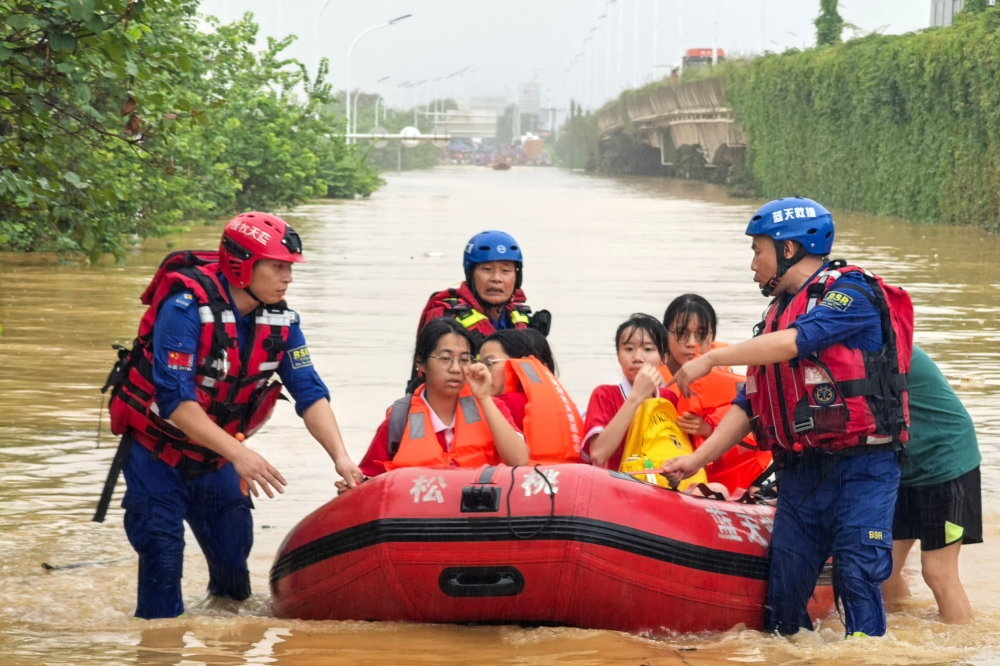 Rescue workers evacuate flood-affected students in Guigang, in China's southern Guangxi region, on July 8, 2026. (Photo by CN-STR / AFP)