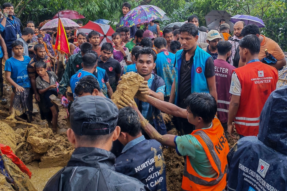 Bangladesh rescue personnel and volunteers work at the site of a landslide triggered by heavy rains at a school in the Kutupalong refugee camp in Cox's Bazar on July 8, 2026. (Photo by AFP)
 