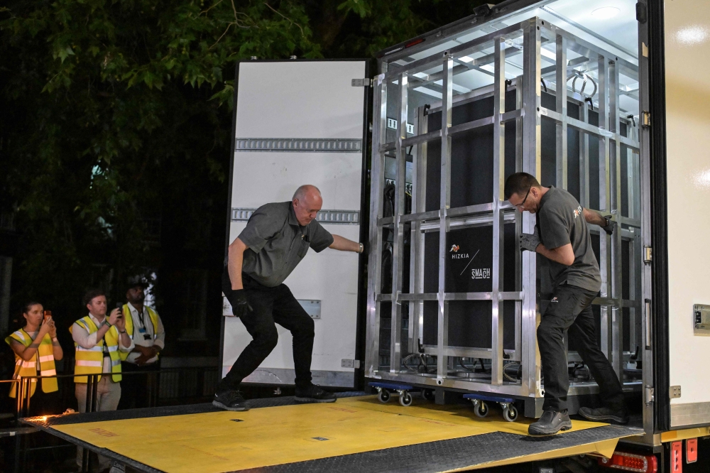 Workers unload a specially designed crate carrying the Bayeux Tapestry at the British Museum in central London early on July 10, 2026. (Photo by Richard A. Brooks / AFP)