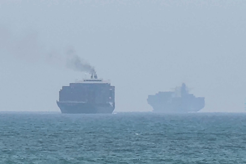 This frame grab taken from AFPTV video footage on July 12, 2026, shows cargo ships anchoring near the Strait of Hormuz off the eastern coast of the United Arab Emirates at Khor Fakkan. (Photo by AFPTV / AFP) 