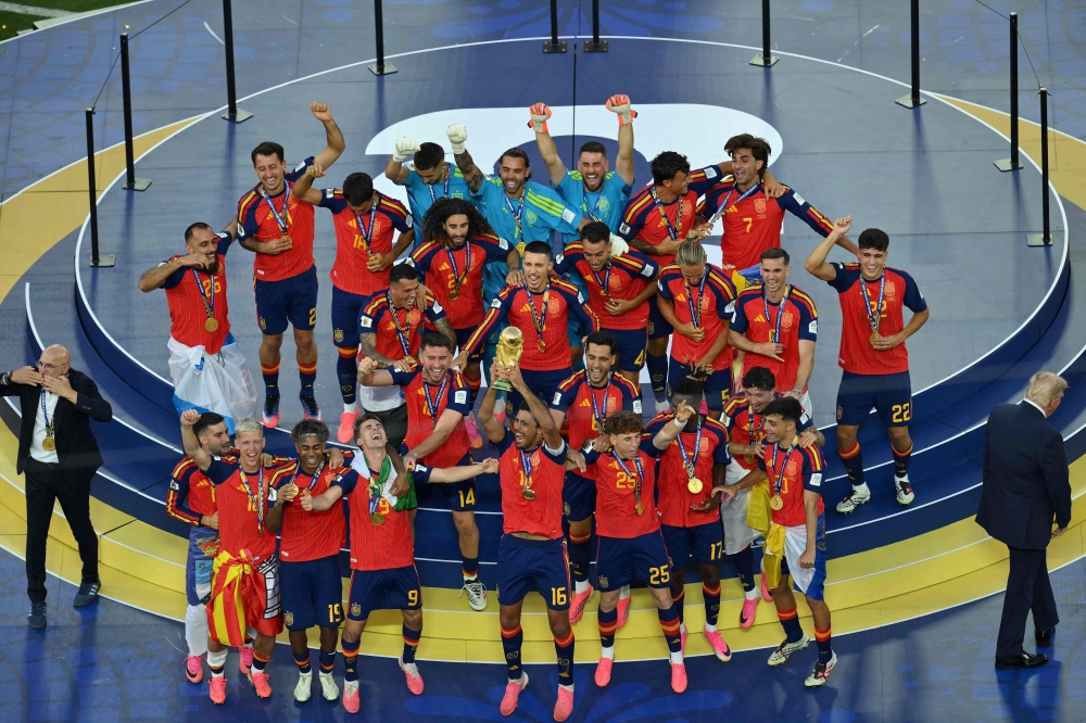 Spain's midfielder #16 Rodri (front C) lifts the trophy with Spain's players next to Spain's head coach Luis de la Fuente (L) and US President Donald Trump (R) on July 19, 2026. (Photo by Angela Weiss / AFP)