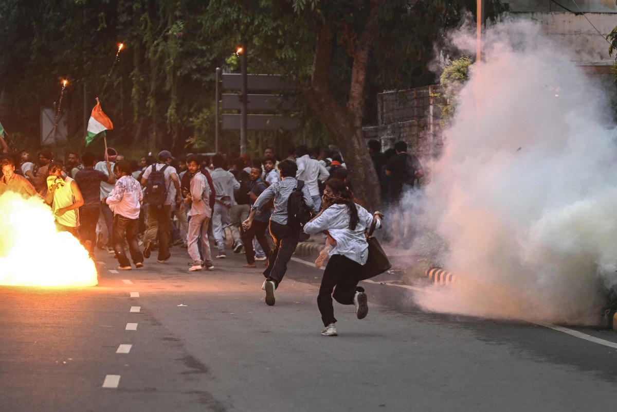 Rapid Action Force (RAF) personnel fire tear gas shells to disperse supporters of the Cockroach Janta Party (CJP) during a protest demanding the resignation of India's Education Minister Dharmendra Pradhan over alleged NEET exam irregularities in New Delhi on July 20, 2026. (Photo by Arun SANKAR / AFP)