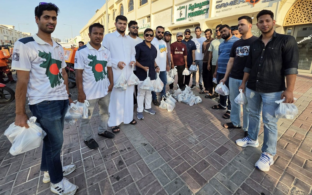 Volunteers from Qatar Probashi Bondhushava distribute refreshments among delivery riders.