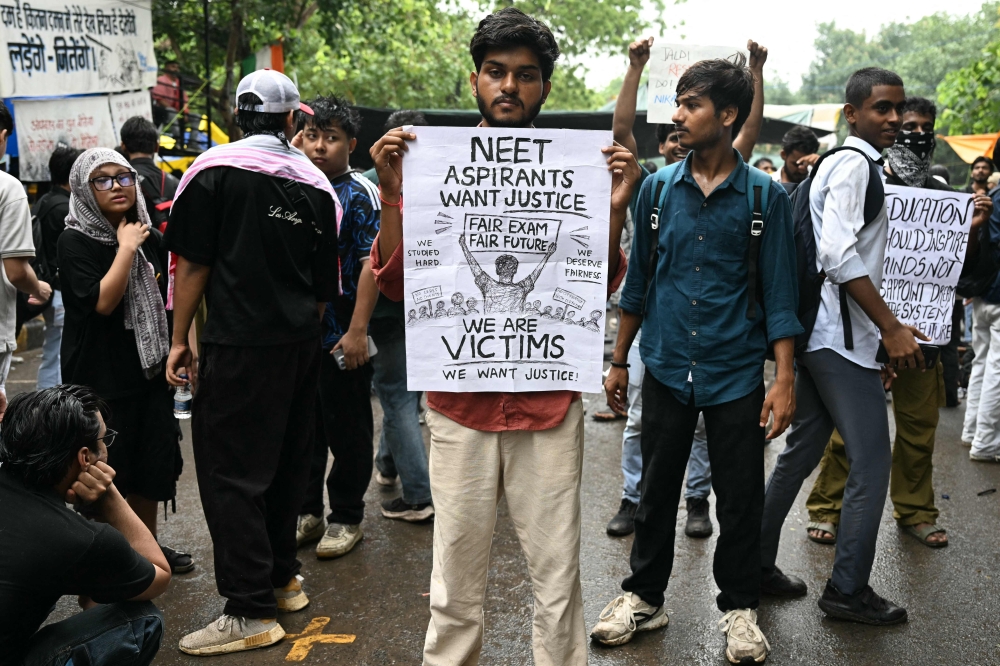 A Cockroach Janta Party (CJP) supporter holds a placard at Jantar Mantar in New Delhi on July 22, 2026. (Photo by Sajjad Hussain / AFP)