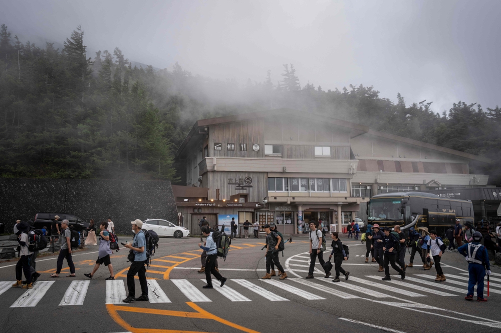Climbers arrive at the fifth station of Mount Fuji in Fujiyoshida, Yamanashi prefecture on July 23, 2026. (Photo by Yuichi Yamazaki / AFP)