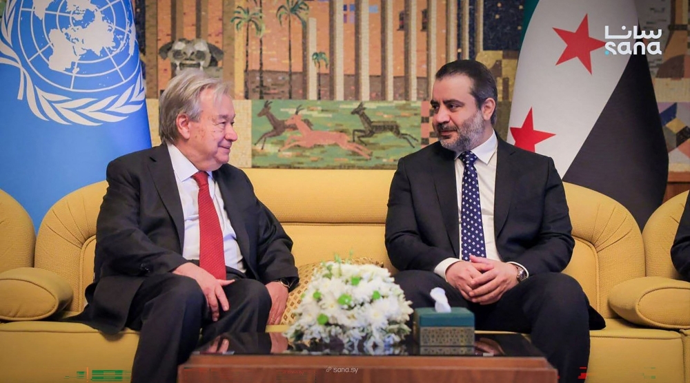 This handout picture taken and released by the official Syrian Arab News Agency (SANA) on July 25, 2026 shows syria's Foreign Affairs Minister Asaad al-Shaibani (R) receiving UN Secretary-General Antonio Guterres (L) at Damascus International Airport in Damascus. (Photo by SANA / AFP)