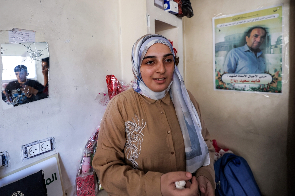 Palestinian high-school student Saba Rabah, the top-ranked student in the science stream of the Palestinian national high school exams, reacts at the Maghazi camp on July 26, 2026. (Photo by Eyad Baba / AFP)
