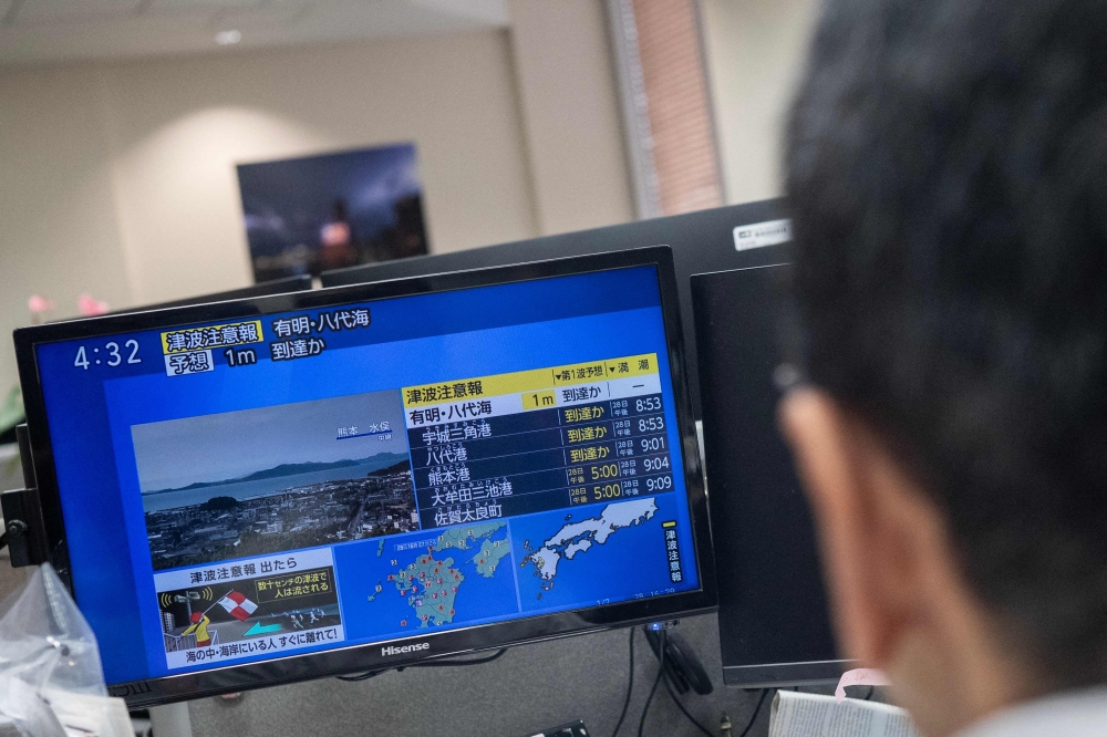 Reporters watch the news showing a large quake and possible one meter tsunami wave in Southern Japan, from an office in Tokyo on July 28, 2026. Photo by Andrew Caballero-Reynolds/ AFP