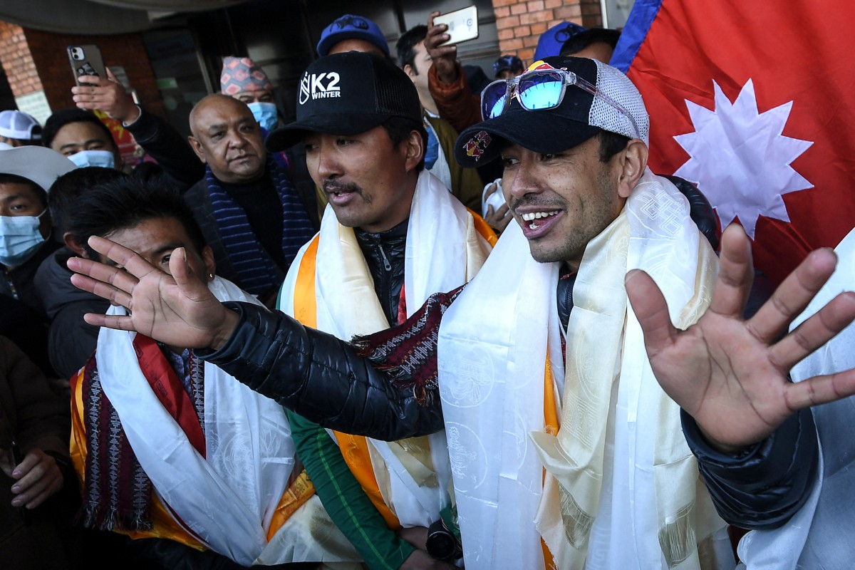 Nepali mountaineer Nirmal Purja (R) talks to the media along with his team at the Tribhuvan International airport after becoming the first to summit Pakistan's K2 mountain in winter, in Kathmandu on January 26, 2021. Photo by PRAKASH MATHEMA / AFP