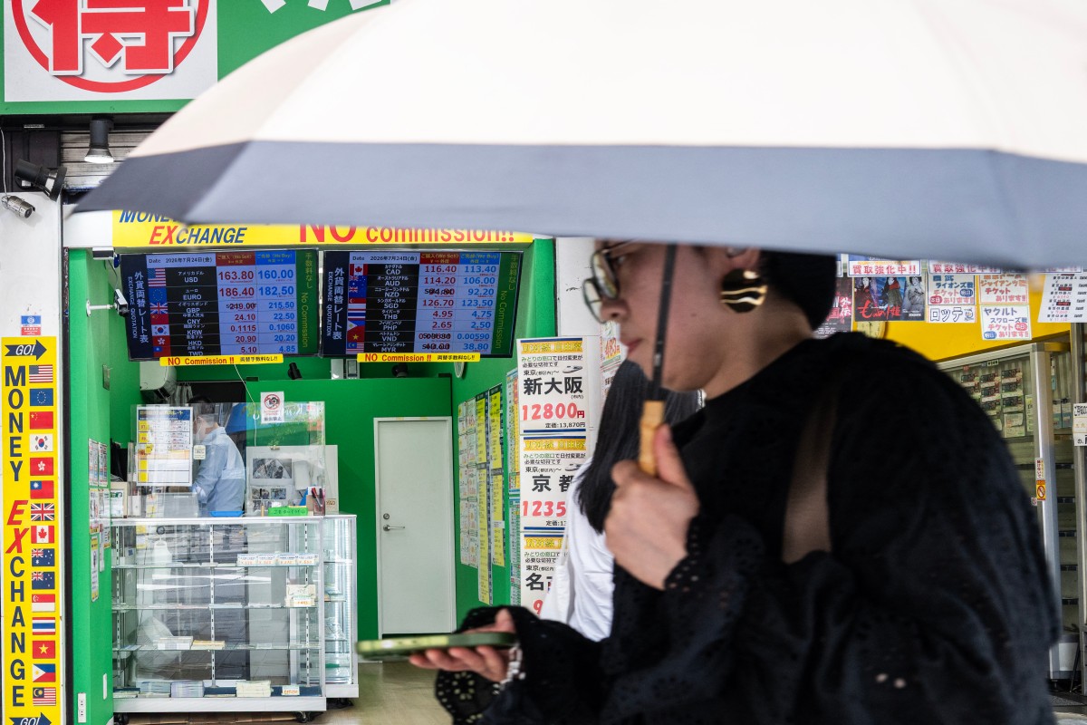 A woman walks past a display showing currency rates at a money exchange in Shinjuku district in Tokyo on July 24, 2026. Photo by ANDREW CABALLERO-REYNOLDS / AFP