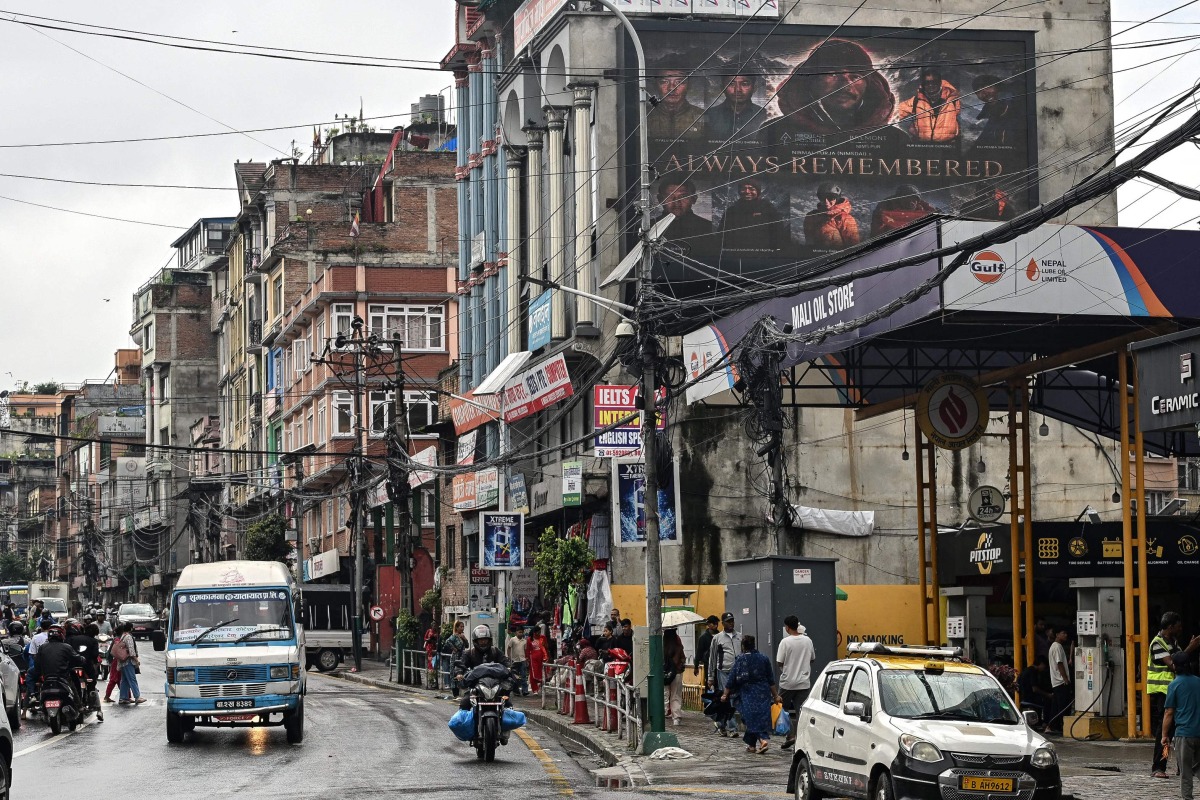 A digital billboard (top, R) displays the condolences after the death of mountaineer Nirmal Purja and his companions by an avalanche in Pakistan, in Kathmandu, on August 2, 2026. Photo by Prakash MATHEMA / AFP