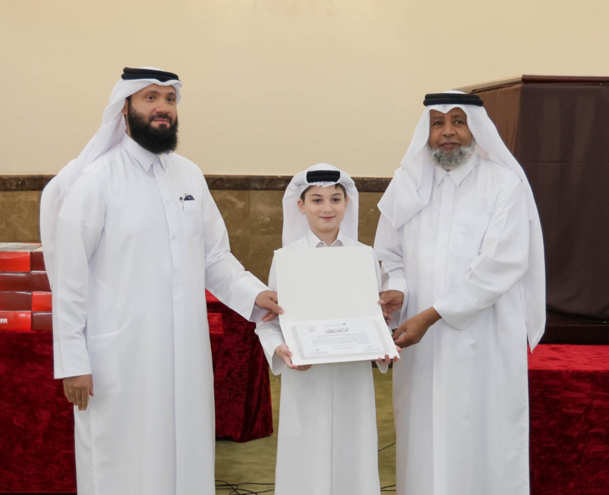 A student receives a certificate from officials at the end of the summer programme.