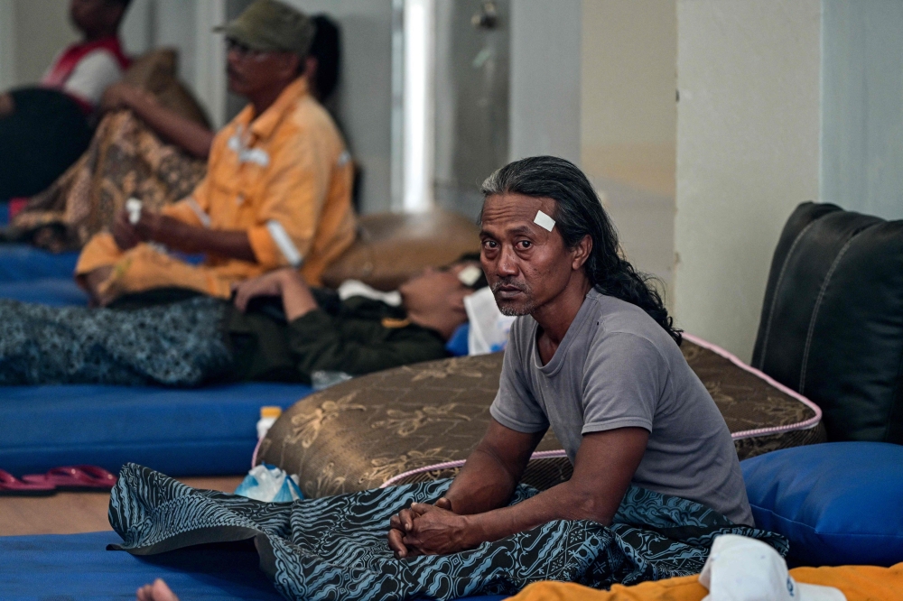 Survivors of the ferry fire recover at Tanjung Perak port in Surabaya on August 3, 2026, a day after the disaster that killed at least five people and prompted many to jump from the vessel into the sea. (Photo by JUNI KRISWANTO / AFP)