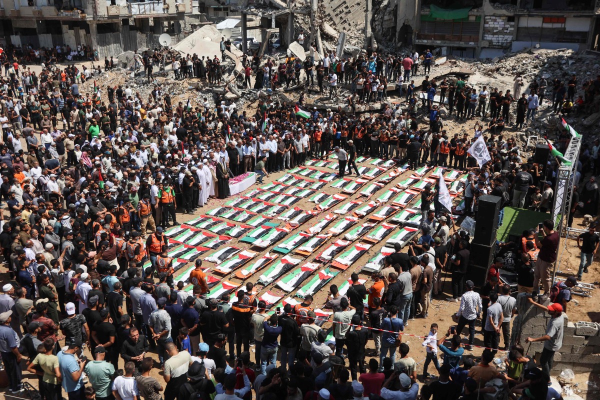 Palestinian mourners attend the funeral of members of the Abu Sharia and Al-Hassaina families, whose remains were recently recovered from the rubble of residential buildings in the al-Sabra neighbourhood which were struck by Israeli bombardments in November 2023, in Gaza City on August 4, 2026. (Photo by Omar AL-QATTAA / AFP)