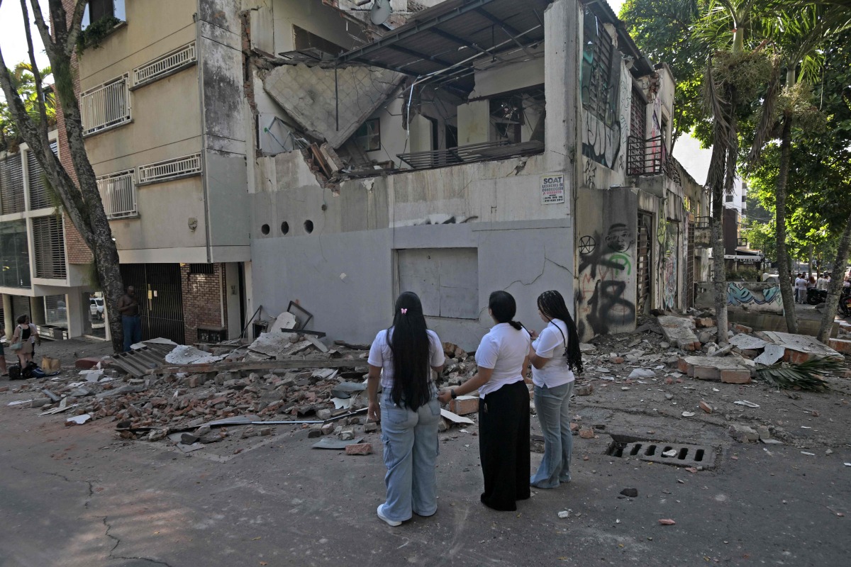 Women look at a damaged building after an earthquake in Cali, Colombia on August 10, 2026. Photo by JOAQUIN SARMIENTO / AFP