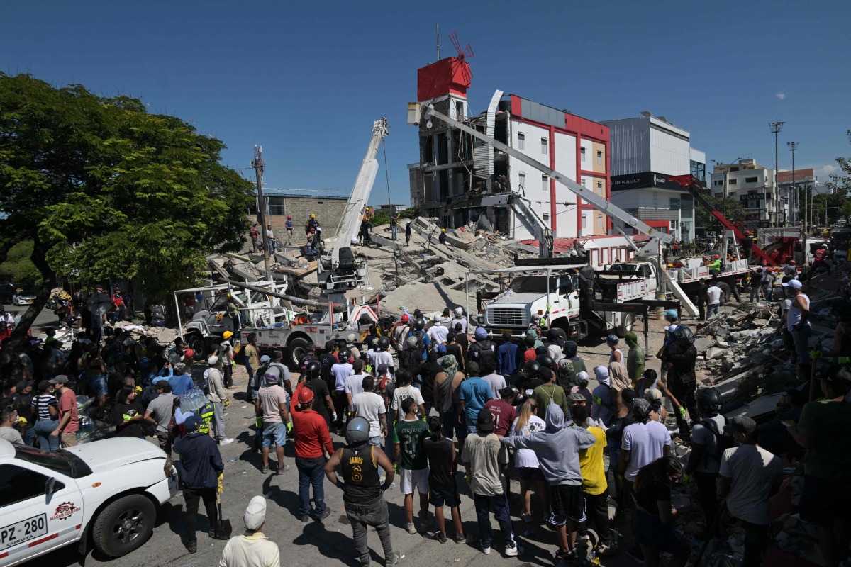 People look for survivors amid the rubble of a collapsed building after an earthquake in Cali, Colombia on August 10, 2026. (Photo by JOAQUIN SARMIENTO / AFP)
