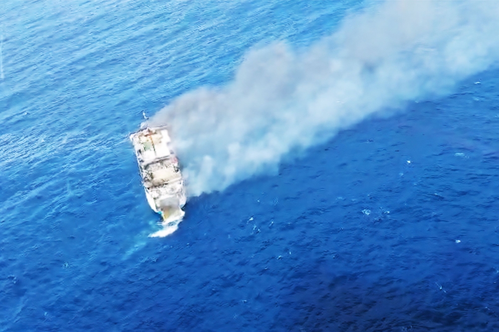 This screen grab picture from a handout video taken and released on August 12, 2026 by the Indonesian National Search and Rescue Agency (Basarnas) shows the Putri Yasmin ferry, which serves the Padangbai-Bali- to Lembar-West Nusa Tenggara route, on fire in the waters of Bali. (Photo by Handout (Green Road Waste Management ) / Indonesian National Search and Rescue Agency (BASARNAS) / AFP)