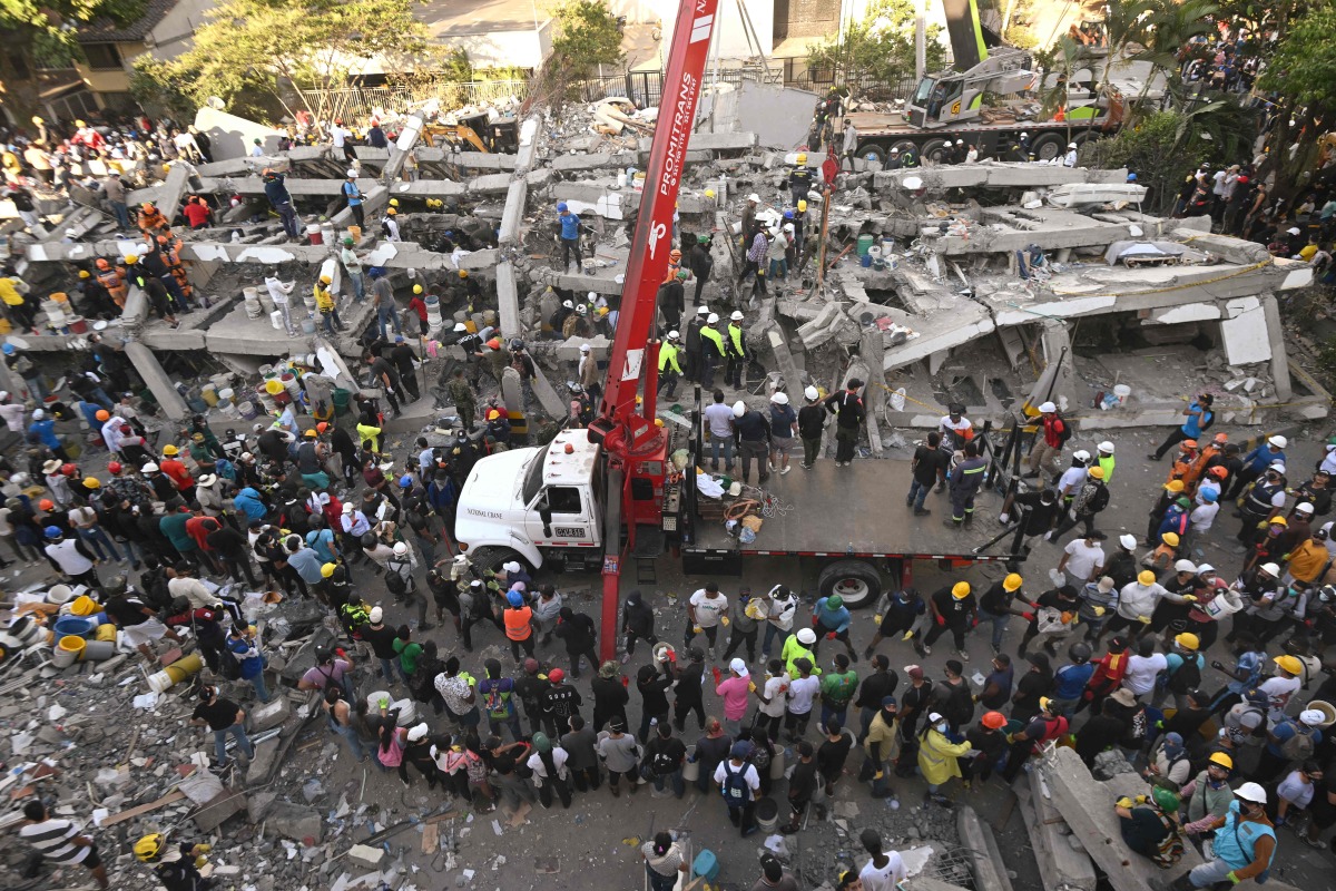 Rescuers and volunteers search for survivors amid the rubble of a collapsed building after an earthquake in Cali, Colombia on August 11, 2026. Photo by JOAQUIN SARMIENTO / AFP
