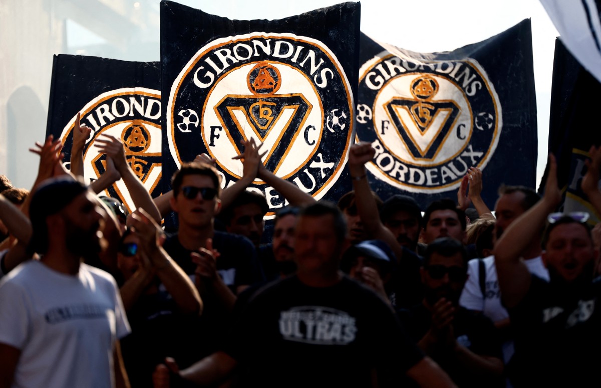 Supporters of French 'Nationale 2' fourth-tier club FC Girondins de Bordeaux wave the club’s flags during a protest ahead of a hearing at the Direction Nationale du Controle de Gestion - DNGG, French football financial watchdog, following the six-time French champions' exclusion from national competitions, in Bordeaux, southwestern France July 19, 2026. Photo by ROMAIN PERROCHEAU / AFP