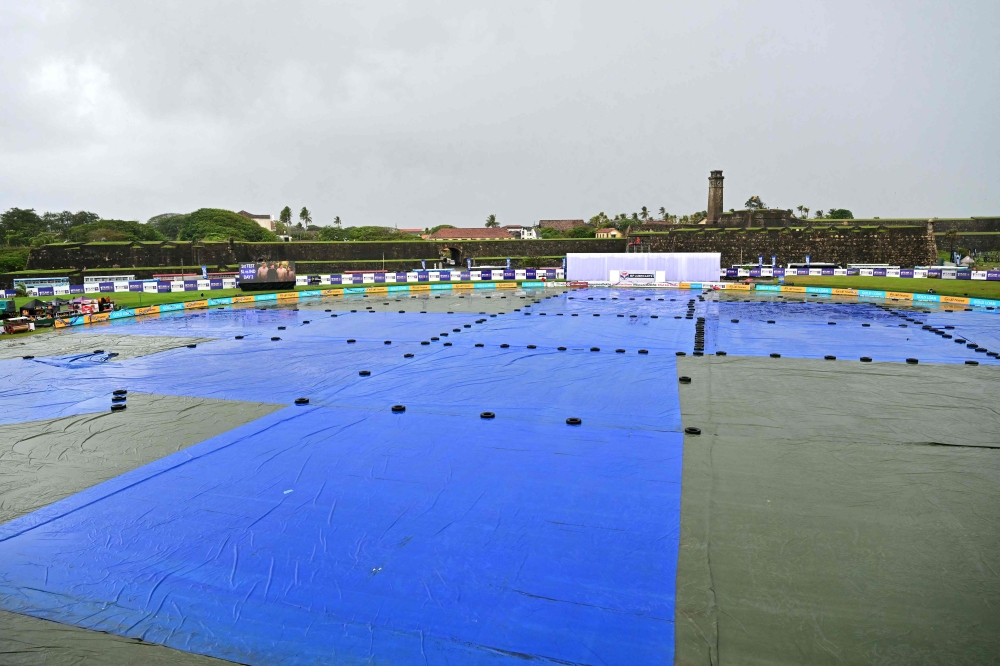 A general view shows covered ground as rain delays the start of play on second day of the first Test cricket match between Sri Lanka and India at the Galle International Stadium in Galle on August 16, 2026. (Photo by Ishara S. KODIKARA / AFP)