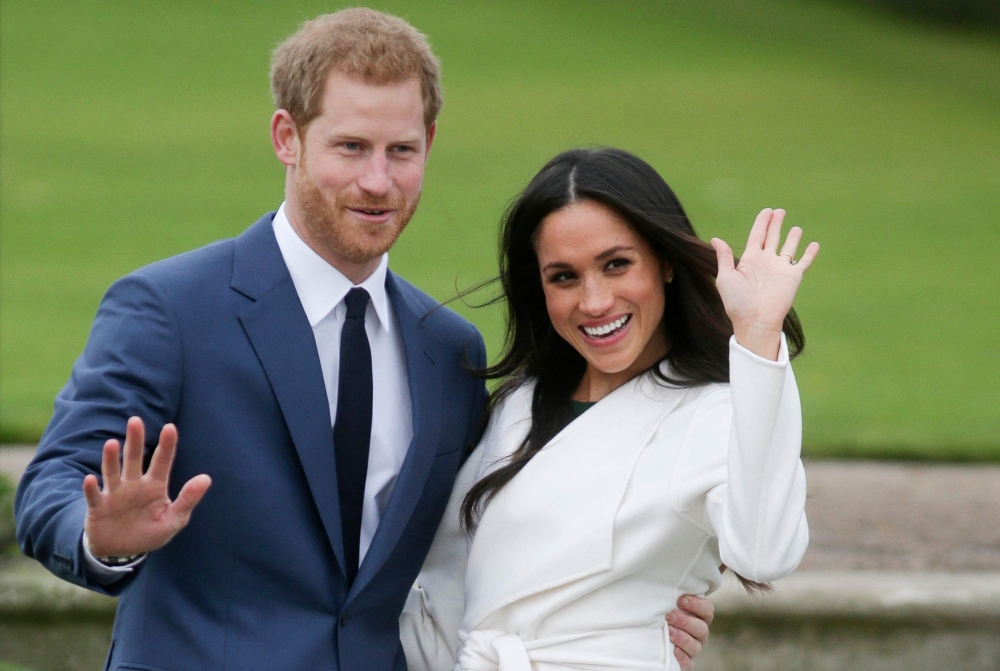 (FILES) Britain's Prince Harry and Meghan Markle pose for a photograph in the Sunken Garden at Kensington Palace in west London on November 27, 2017, following the announcement of their engagement. (Photo by Daniel LEAL / AFP)