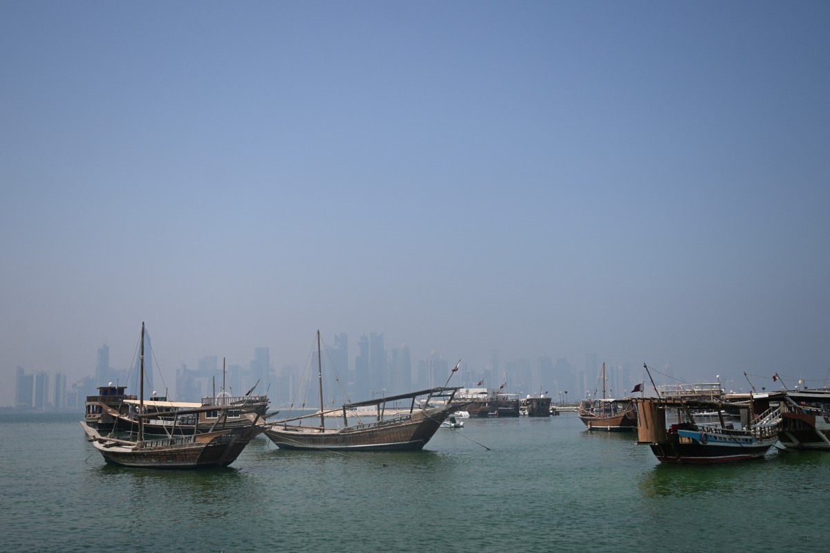 Traditional wooden boats are anchored in front of the Doha skyline on August 19, 2026. (Photo by Mahmud Hams/ AFP)
