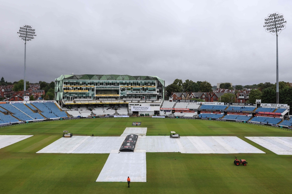 The covers stay on the pitch as rain delays the start of day two of the first Test match between England and Pakistan at Headingley cricket ground in Leeds, northern England on August 20, 2026. (Photo by Darren Staples / AFP) 