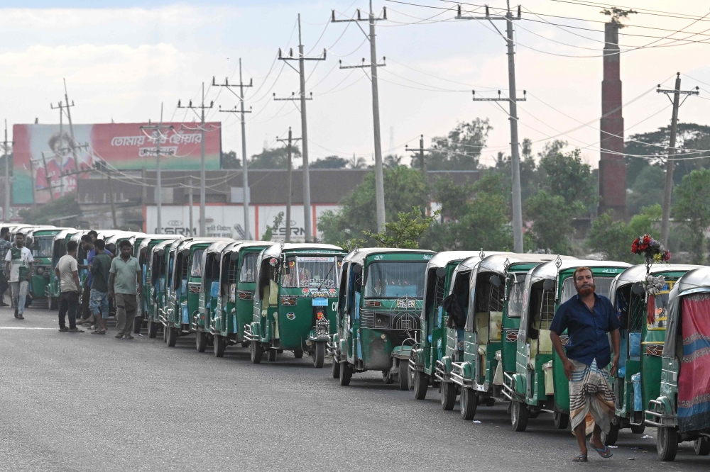 This photograph taken on August 12, 2026 shows CNG-powered autorickshaws waiting for long hours to refuel in Bangladesh's Brahmanbaria district. (Photo by Salahuddin Ahmed / AFP)