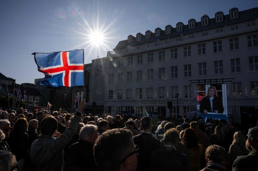 A participant waves an Icelandic flag during a rally of supporters of the 'No' campaign against reopening Iceland's European Union accession negotiations in Reykjavik, Iceland, on August 27, 2026, two days ahead of a national referendum. Icelanders will vote on August 29 on whether the country should resume EU accession negotiations, which were suspended in 2013. (Photo by Jonathan NACKSTRAND / AFP)