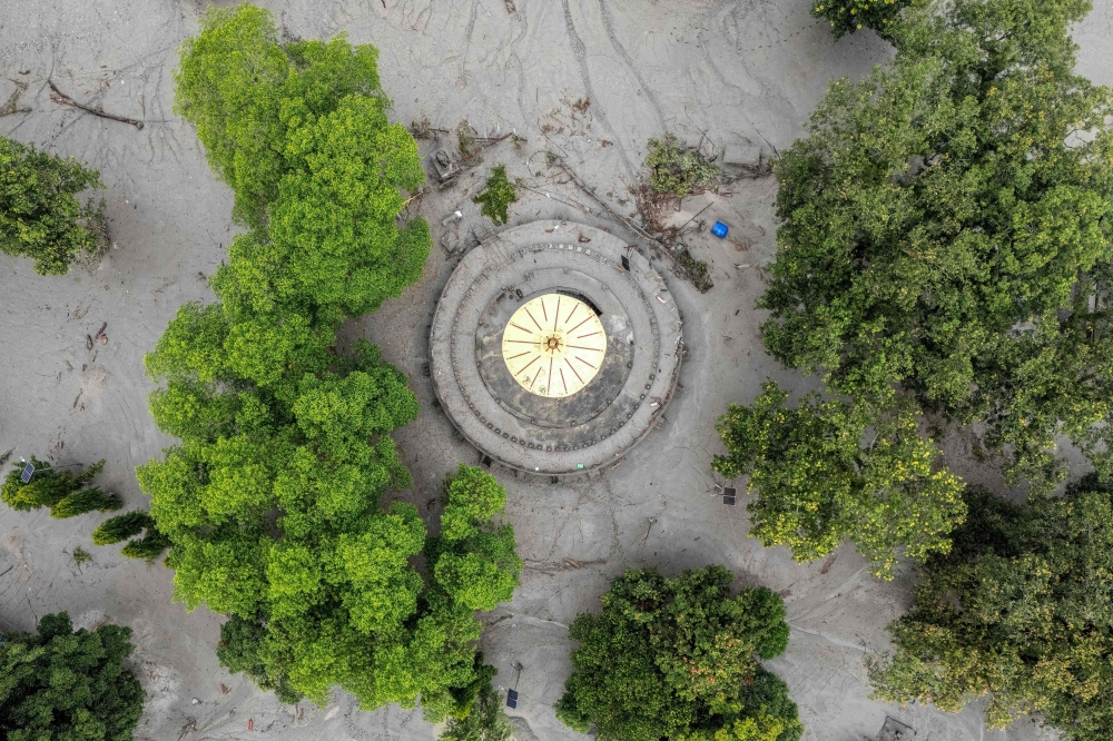 This aerial photograph shows the Neelkantha Hindu temple covered heavily under sludge in the aftermath of flash floods at Devighat in Nepal's Nuwakot district on August 29, 2026. (Photo by Manan VATSYAYANA / AFP)