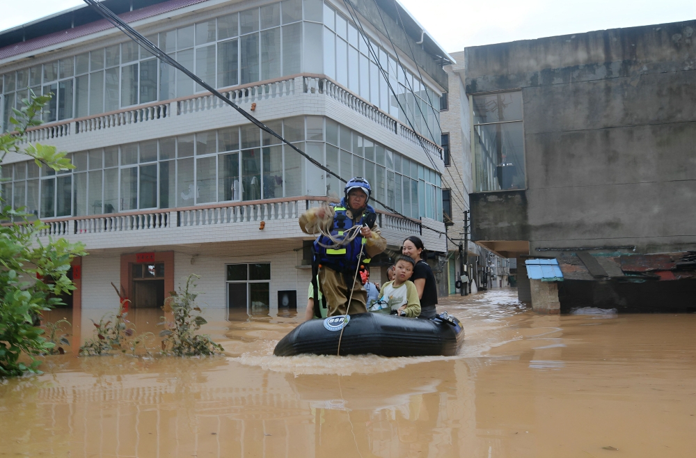 A member of a search and rescue team evacuates people from floods affected area following heavy rains in Suichuan, Central China's Jiangxi province on September 4, 2026. (Photo by CN-STR / AFP) / China OUT