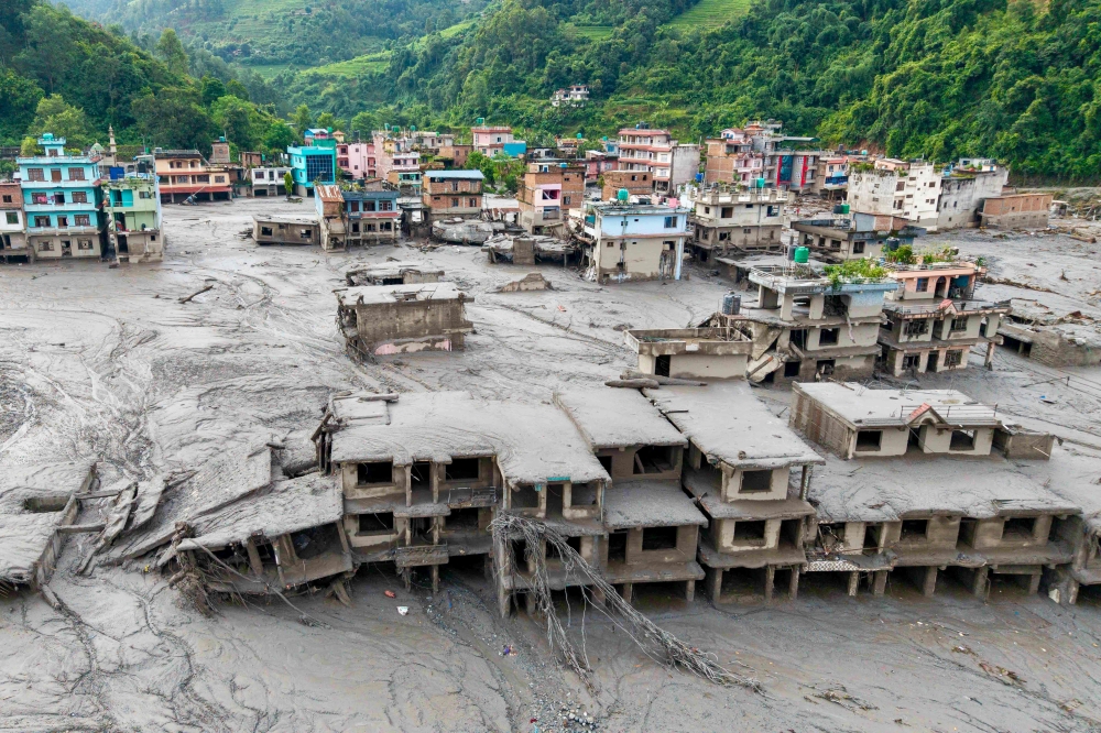 (Files) An aerial view shows houses lying deluged in sludge after flash floods at Devighat, Bidur Municipality in Nepal's Nuwakot district on August 27, 2026. (Photo by Prabin Ranabhat / AFP)