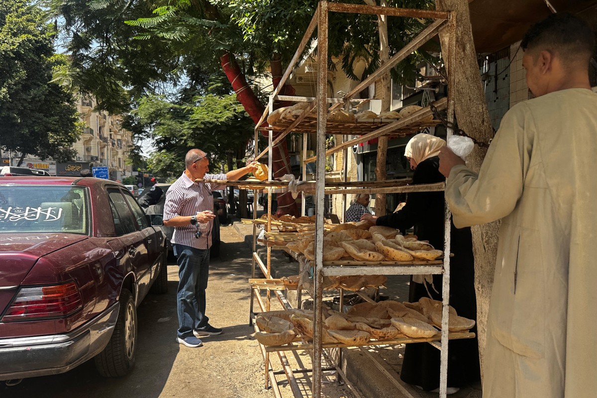 People queue outside a bakery to buy government-subsidised traditional pita bread in Cairo on August 17, 2026. Photo by Khaled Desouki / AFP

