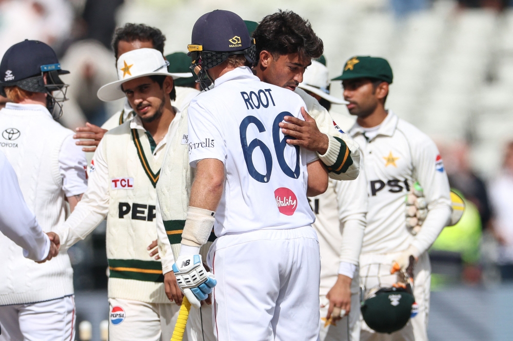 England's Joe Root (C) hugs Pakistan's Razaullah (2nd R) at the end of play on day four of the third Test match between England and Pakistan at Edgbaston cricket ground in Birmingham, central England, on September 12, 2026. (Photo by Darren Staples / AFP)