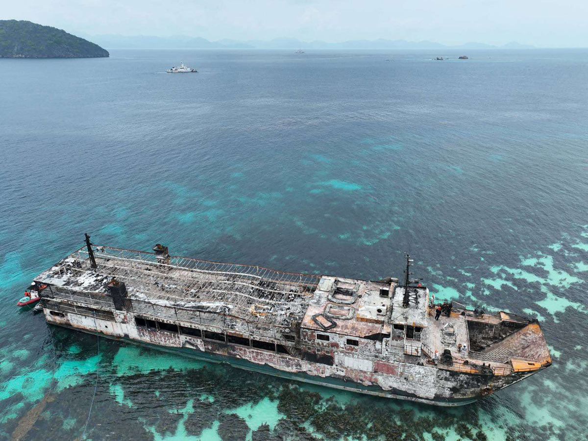 This handout photo taken on September 11, 2026 and released by the Philippine coast Guard (PCG), shows an aerial shot of the ill-fated M/V June Aster with coast guard personnel on board (bridge) off the shores of Coron town, Palawan province. (Photo by Handout / Philippine Coast Guard (PCG) / AFP)