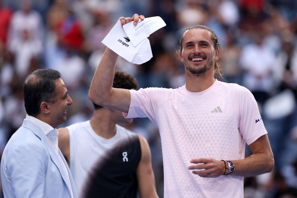 Alexander Zverev of Germany celebrates with the winner's check after defeating Ben Shelton of the United States in their Men's Singles Final match on Day Fifteen of the 2026 US Open at USTA Billie Jean King National Tennis Center on September 13, 2026 in the Flushing neighborhood of the Queens borough of New York City. (Photo by  Matthew Stockman/Getty Images/AFP) 