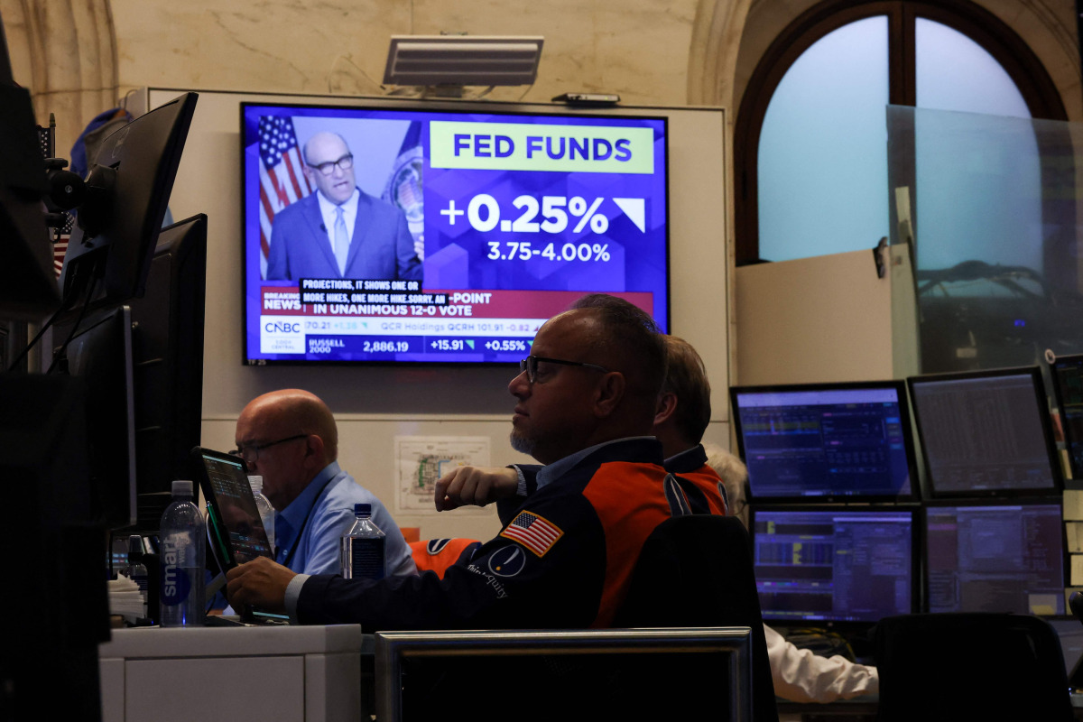 A television displays news of the US Federal Reserve's interest rate hike as traders work on the floor of the New York Stock Exchange (NYSE) in New York on September 16, 2026. (Photo by TIMOTHY A. CLARY / AFP)