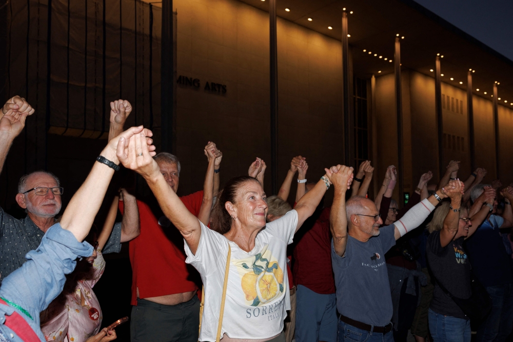 Demonstrators hold hands to form a human chain during a rally outside the John F. Kennedy Center for the Performing Arts on September 18, 2026 in Washington, DC. Tom Brenner/Getty Images/AFP 
 