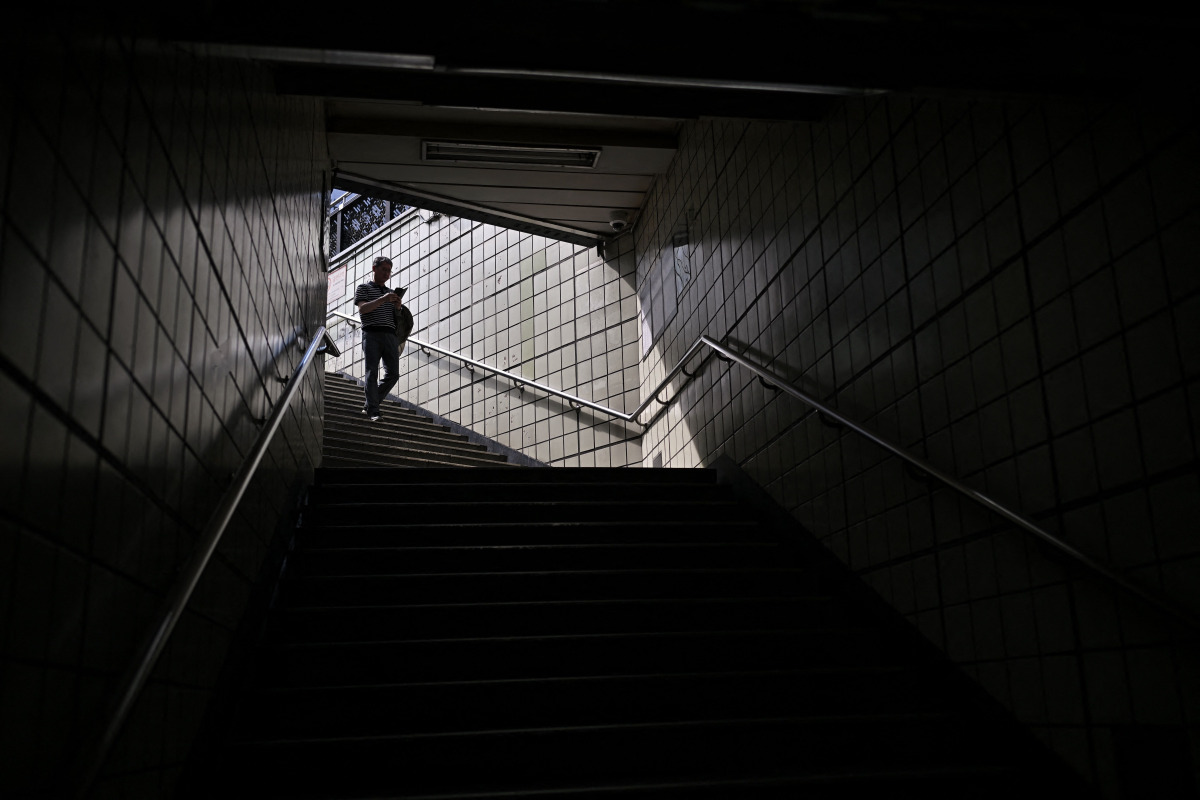 A person walks down the entrance of a metro station in Seoul on September 20, 2026. (Photo by Lillian SUWANRUMPHA / AFP)