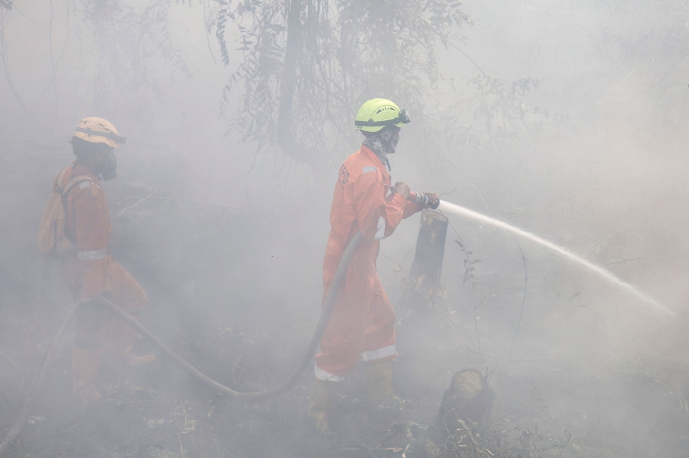 Firefighters extinguish forest and land fires in Banjar, South Kalimantan, on September 21, 2026. (Photo by Muda Sagala / AFP)