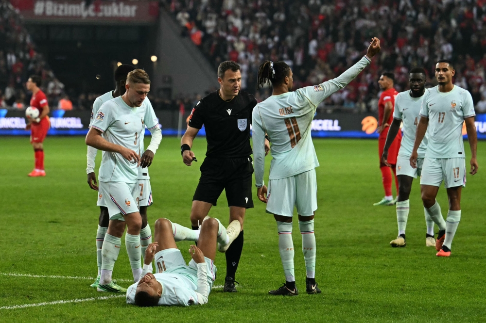 France's forward #10 Kylian Mbappe (C) reacts after scoring the opening goal and to a leg pain on September 25, 2026. (Photo by Ozan Kose / AFP)