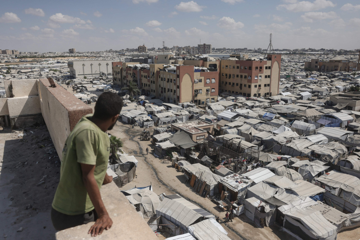 A man standing on top of a building looks at tents of displaced Palestinians in Al-Mawasi area of Khan Yunis in the southern Gaza Strip on September 25, 2026. (Photo by BASHAR TALEB / AFP)