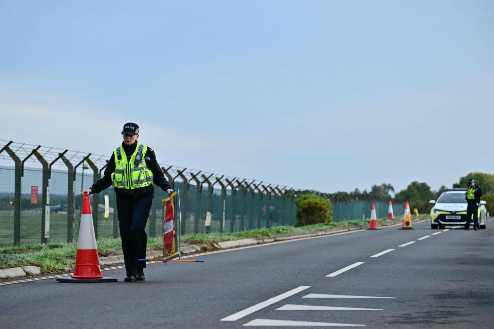 Police continue to man a roadblock outside RAF Fairford base (L) in Fairford, south-west England on September 28, 2026. (Photo by Ben Stansall / AFP)