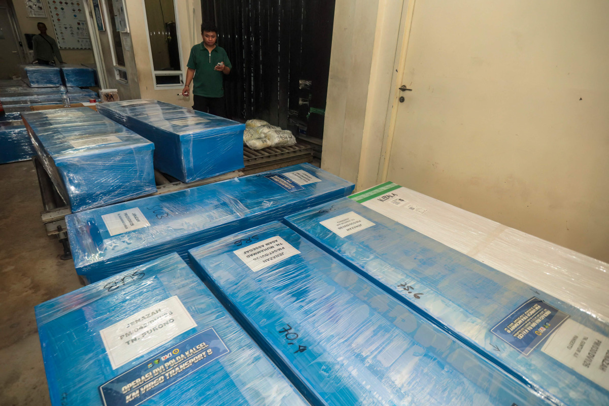 Coffins containing the identified remains of victims from the Virgo 8 ship disaster are prepared for repatriation to their respective hometowns at Syamsudin Noor Airport in Banjarbaru, South Kalimantan province, Indonesia on September 28, 2026. (Photo by MUDA SAGALA / AFP)