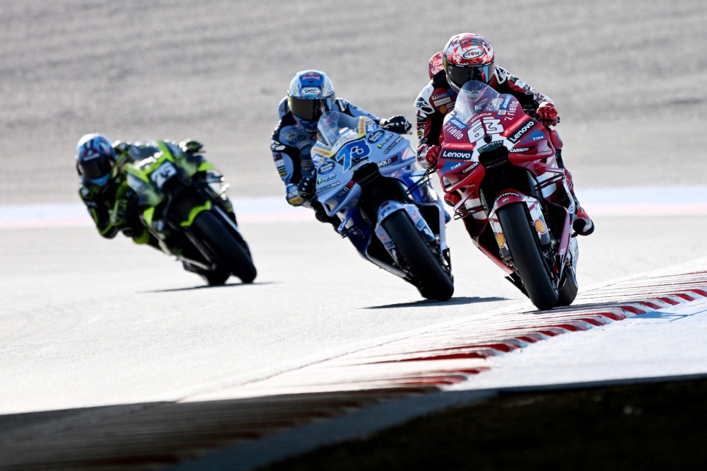 Ducati Lenovo Team rider Francesco Bagnaia of Italy (R) leads BK8 Gresini Racing MotoGP rider Alex Marquez of Spain (C) and SuperFile Trackhouse MotoGP Team rider Raul Fernandez of Spain (L) during the MotoGP class practice session of MotoGP Japanese Grand Prix at the Mobility Resort Motegi in Motegi, Tochigi prefecture on October 2, 2026. (Photo by Toshifumi KITAMURA / AFP)
